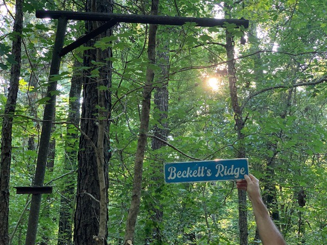 Beckett’s Ridge sign among the trees on the property
